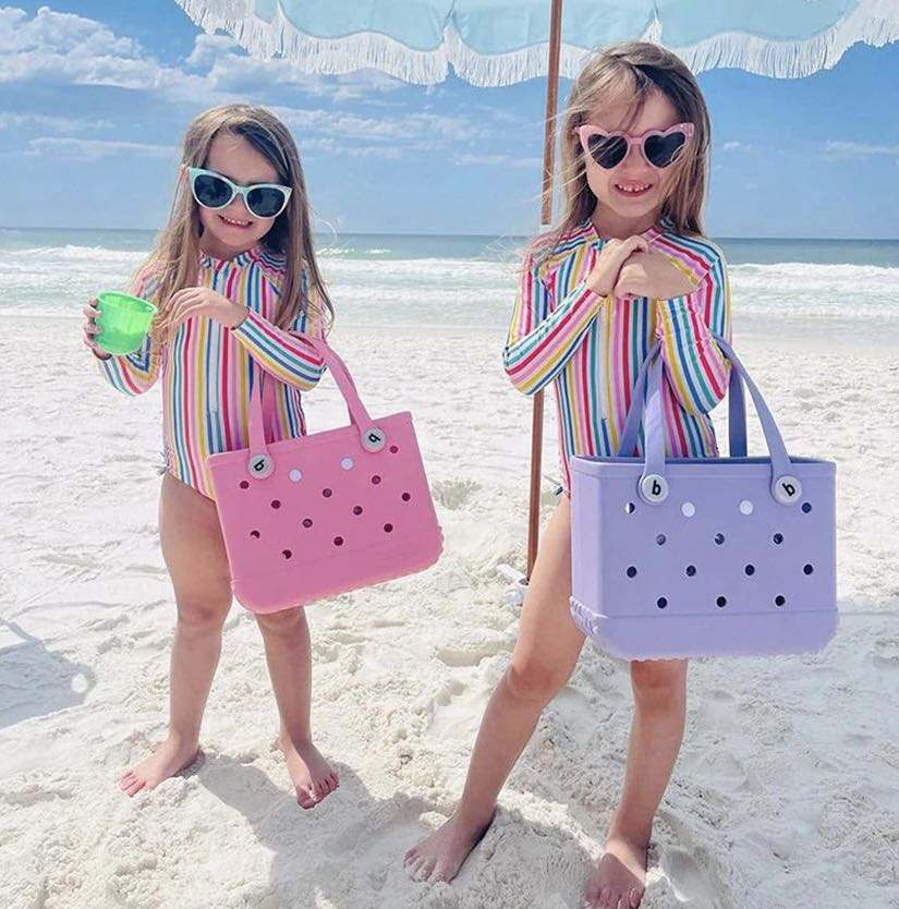 Small Bogg Bag – compact mint-colored EVA tote with handles
Small Bogg Bag in blush pink – front view on flat surface
Portability demo – small Bogg Bag styled over wrist or shoulder
Assorted Small Bogg Bags in fun color collection