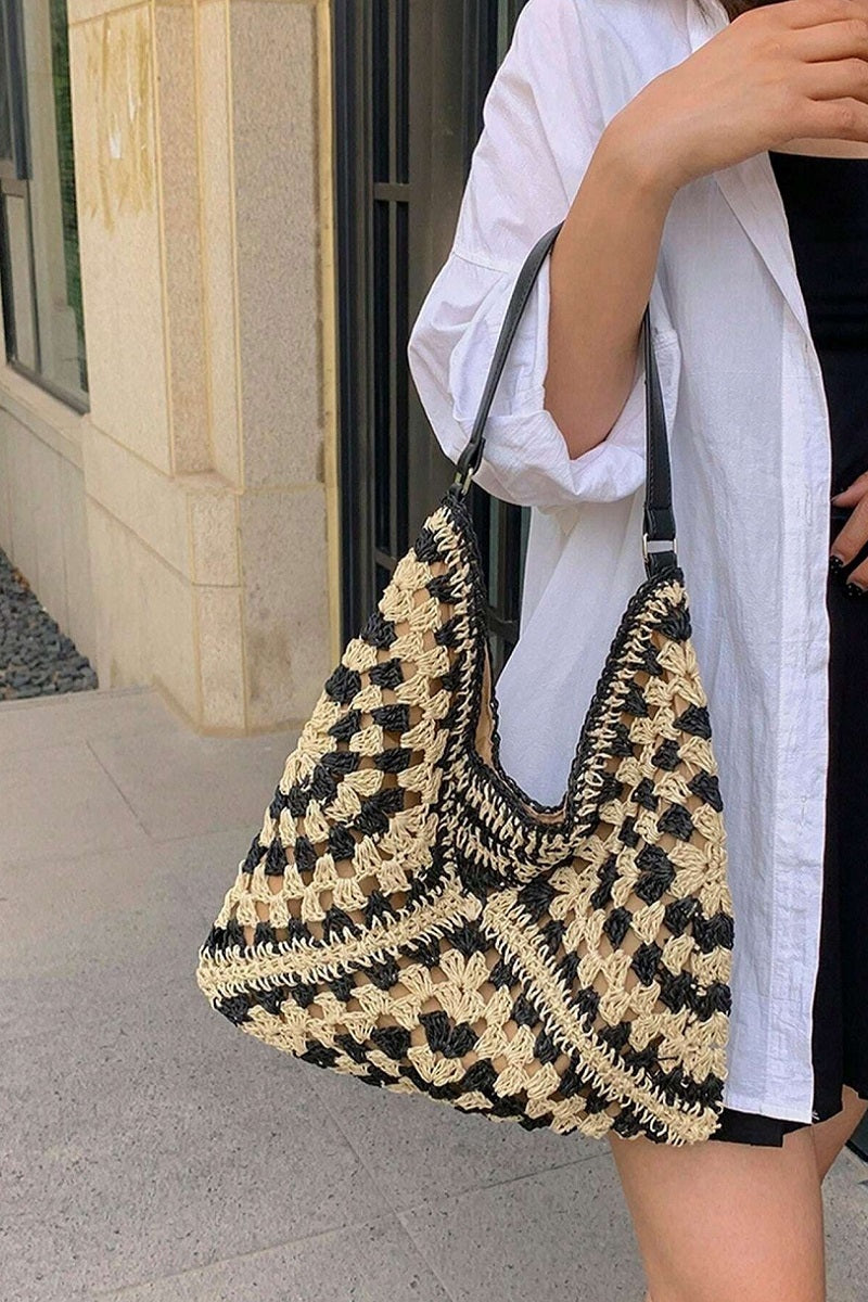 Vintage woven straw crochet bucket shoulder bag in natural straw tones
Close-up of crochet straw texture and shoulder strap detail
Bucket bag styled cross-body over floral dress or casual outfit