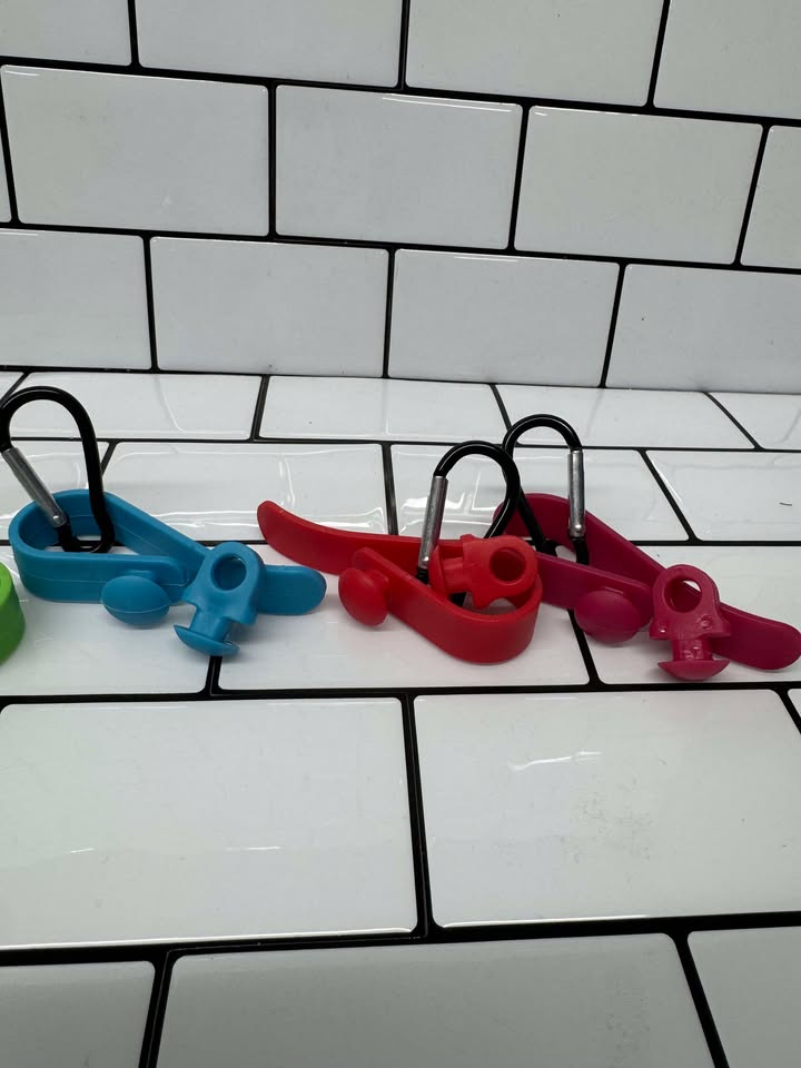 Bogg Bag Hook clipped into Bogg Bag rim holding keys & charm
Close-up of colored snap-in EVA hook in Bogg Bag hole
Multiple hooks displayed in assorted colors beside Bogg Bag
Hook holding AirTag and sunglasses attached to Bogg Bag