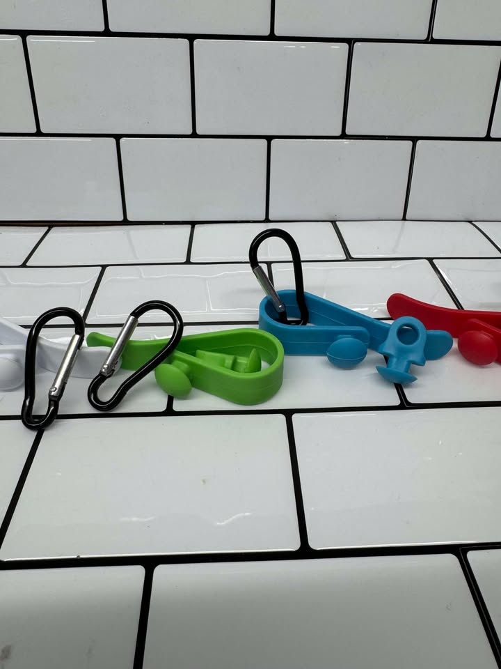 Bogg Bag Hook clipped into Bogg Bag rim holding keys & charm
Close-up of colored snap-in EVA hook in Bogg Bag hole
Multiple hooks displayed in assorted colors beside Bogg Bag
Hook holding AirTag and sunglasses attached to Bogg Bag