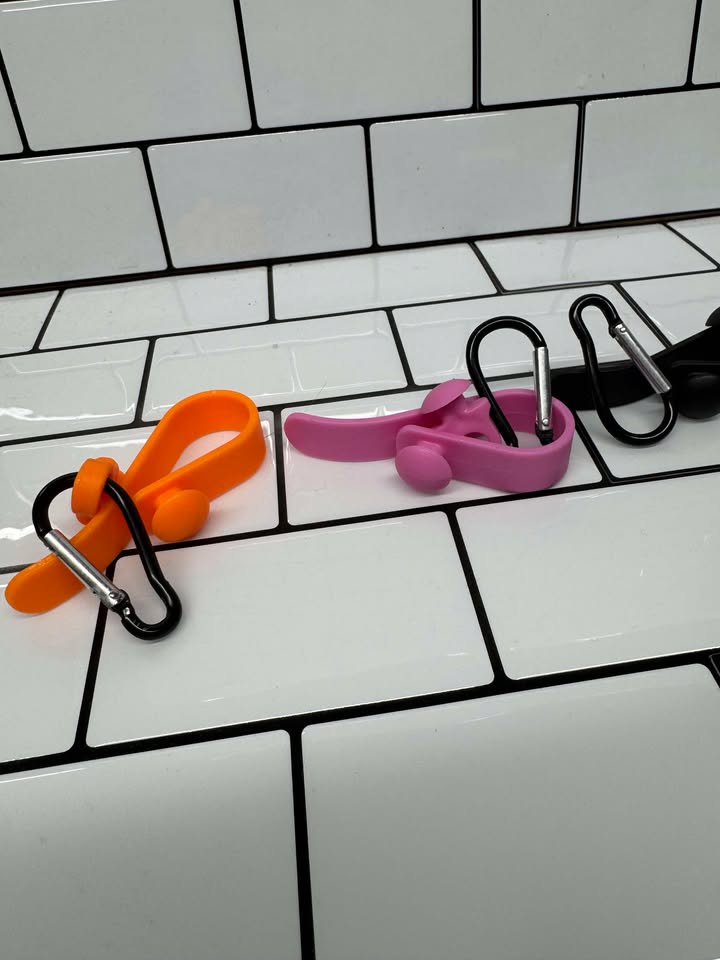 Bogg Bag Hook clipped into Bogg Bag rim holding keys & charm
Close-up of colored snap-in EVA hook in Bogg Bag hole
Multiple hooks displayed in assorted colors beside Bogg Bag
Hook holding AirTag and sunglasses attached to Bogg Bag