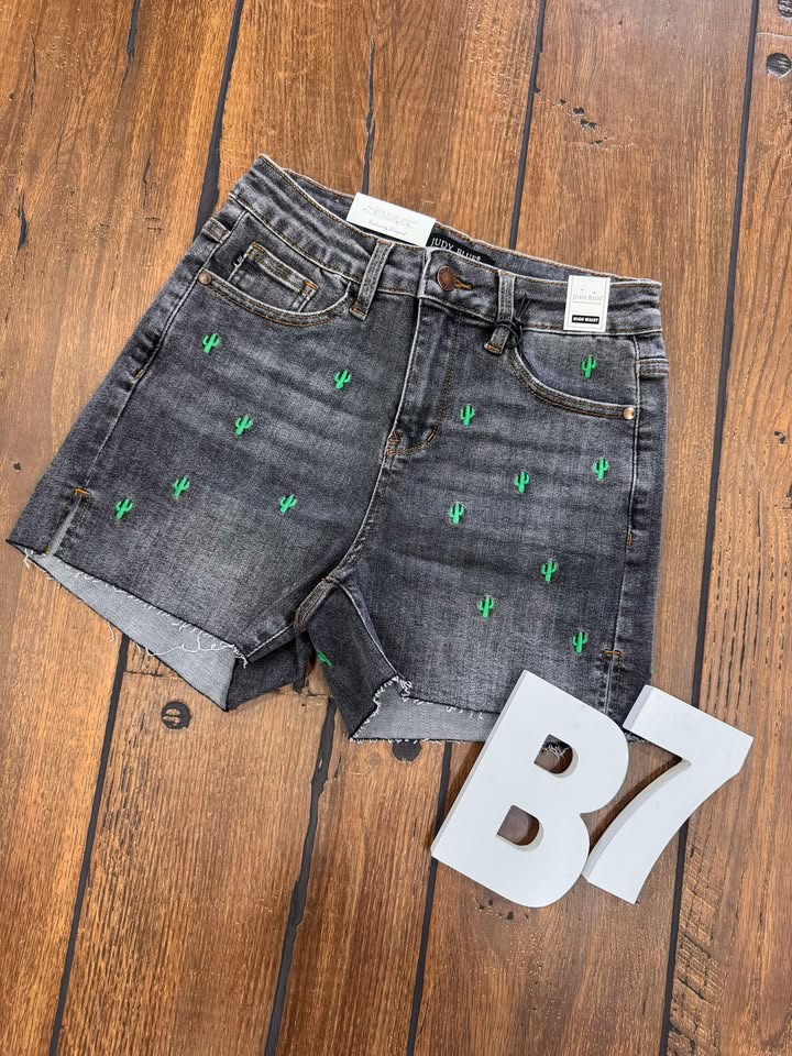 “Hi‑waisted denim shorts with cactus embroidery and cut‑off hem”
“Judy Blue cactus embroidery shorts in high‑rise cut‑off denim”
“Stretch denim shorts with cactus detailing and frayed hem”
