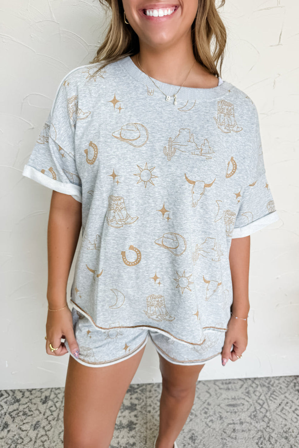 Gray Western print tee and shorts set front view – boutique lounge co‑ord
Gray Western print tee and shorts set back view – matching tee and elastic waist shorts
Gray Western print tee and shorts set styled outfit – casual Western lounge set
Gray Western print tee and shorts set fabric close‑up – soft breathable knit material
Gray Western print tee and shorts set flat lay – matching tee and shorts boutique set