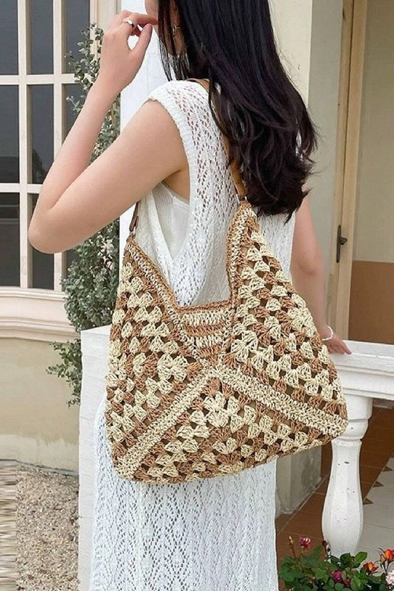 Vintage woven straw crochet bucket shoulder bag in natural straw tones
Close-up of crochet straw texture and shoulder strap detail
Bucket bag styled cross-body over floral dress or casual outfit