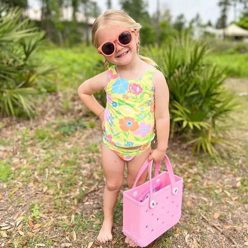 Small Bogg Bag – compact mint-colored EVA tote with handles
Small Bogg Bag in blush pink – front view on flat surface
Portability demo – small Bogg Bag styled over wrist or shoulder
Assorted Small Bogg Bags in fun color collection