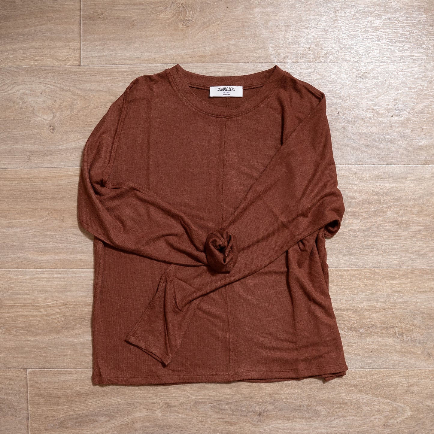 Brown long-sleeve top on a wooden surface