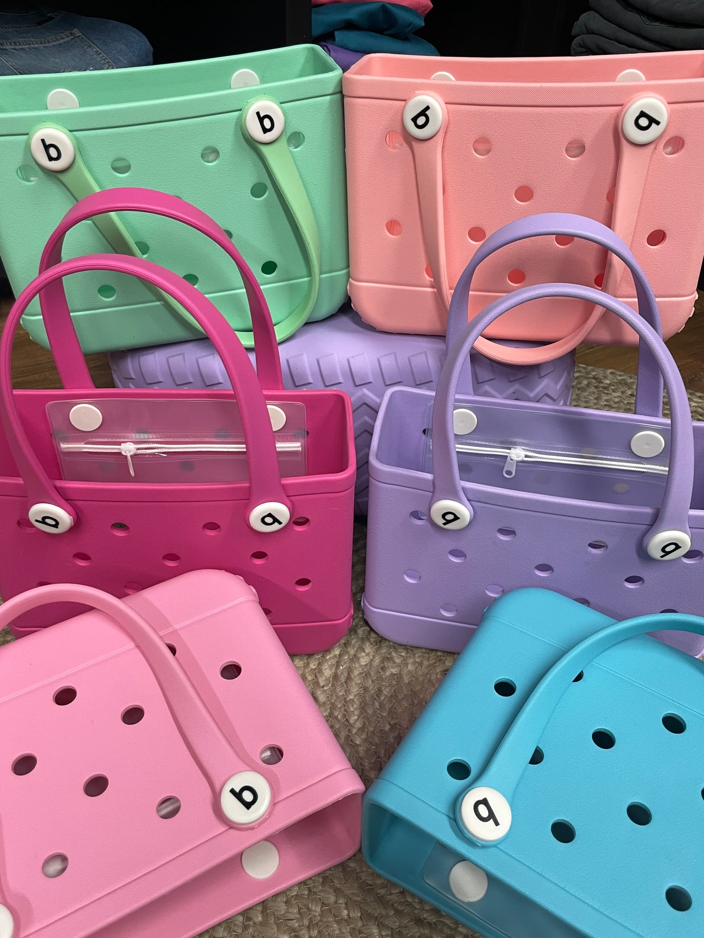 Small Bogg Bag – compact mint-colored EVA tote with handles
Small Bogg Bag in blush pink – front view on flat surface
Portability demo – small Bogg Bag styled over wrist or shoulder
Assorted Small Bogg Bags in fun color collection