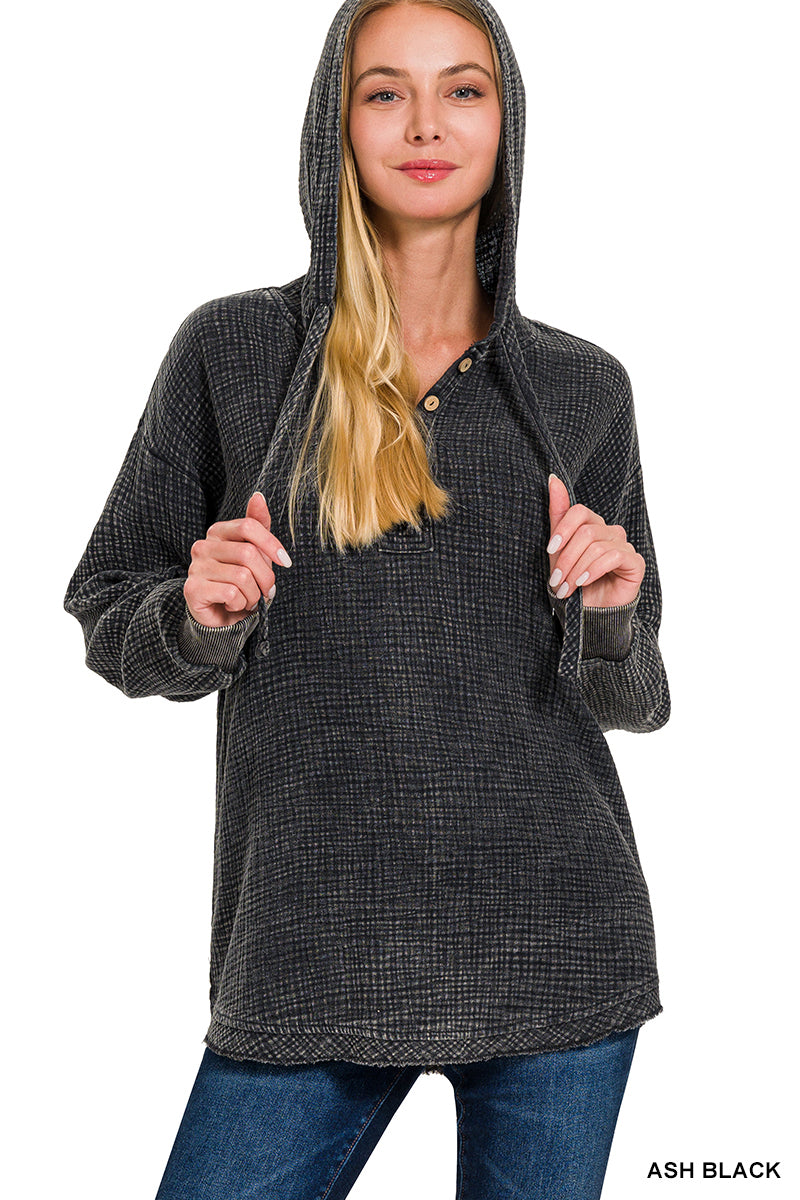 Washed double gauze button closure hoodie in black, laid flat
Close-up of double gauze texture and button details on hoodie
Model wearing the hoodie in Marlin with relaxed layering