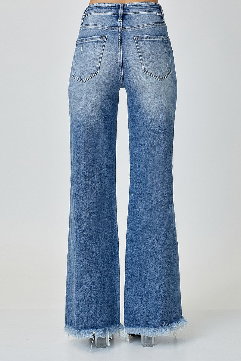 “Risen mid-rise wide leg jeans with button front closure”
“Stretch denim wide leg flare showing button fly detail”
“Wide-leg jeans styled with cropped top and boots”