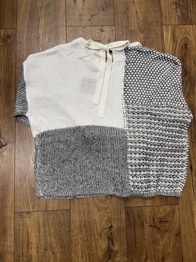 Grey multi-stripe colorblock crochet sheer knit sweater in open crochet with boat neck
Close-up of crochet knit texture and colorblock stripe pattern
Back view showing self-tie boat neckline detail