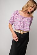 Floral printed poly crepe top tie-front in lavender color laid flat
Close-up of floral print and textured crepe fabric
Model wearing the Easel floral top in peri blue variant