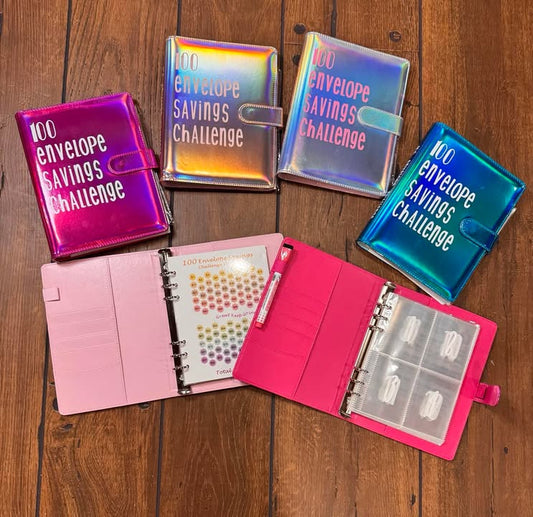 100 Envelope Savings Challenge binder in black with tracker sheet and envelopes

Pastel color binders open to interior pockets and numbered envelope sleeves

Insert pages showing pocketed envelopes and tracker card grid

Stylish stack of multiple-colored savings binders (mint, lavender, pink)