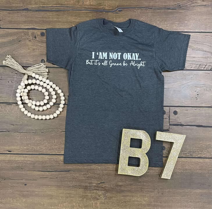 “I Am Not Okay But It’s All Gonna Be Alright” Graphic Tee – Uplifting & Relatable Everyday Comfort 🌤️