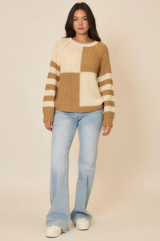 Woman wearing a checkered sweater and jeans on a beige background