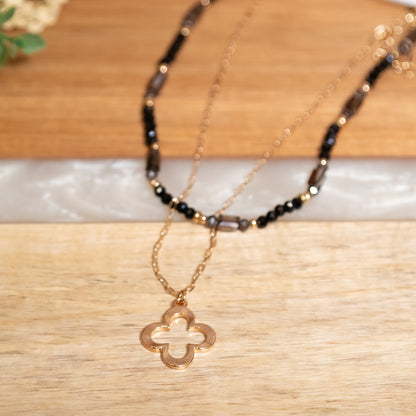 Necklace with a four-leaf clover pendant on a wooden surface
