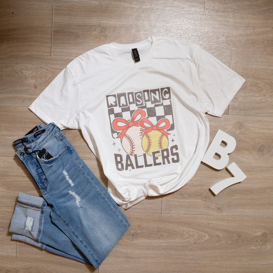 Raising Ballers Graphic Tee – Sports Mom Softball Baseball T-Shirt with Bows