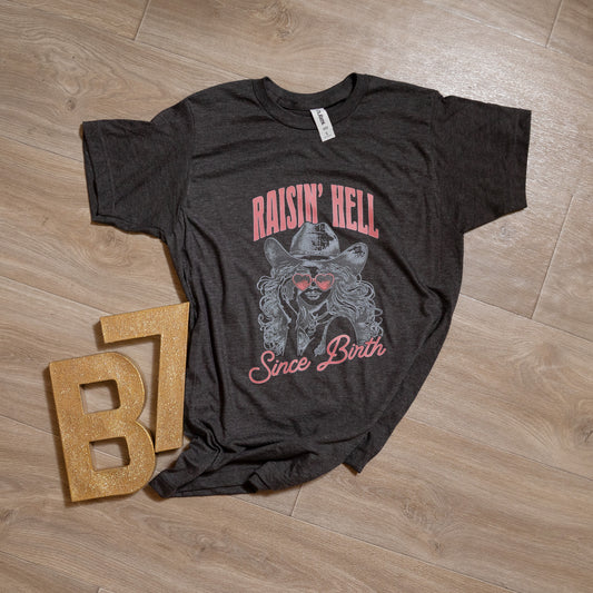 Raisin’ Hell Since Birth Graphic Tee – Western Cowgirl T-Shirt with Heart Sunglasses