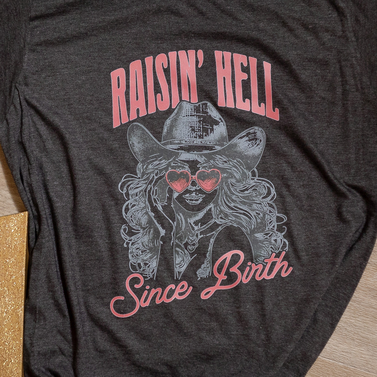 Raisin’ Hell Since Birth Graphic Tee – Western Cowgirl T-Shirt with Heart Sunglasses