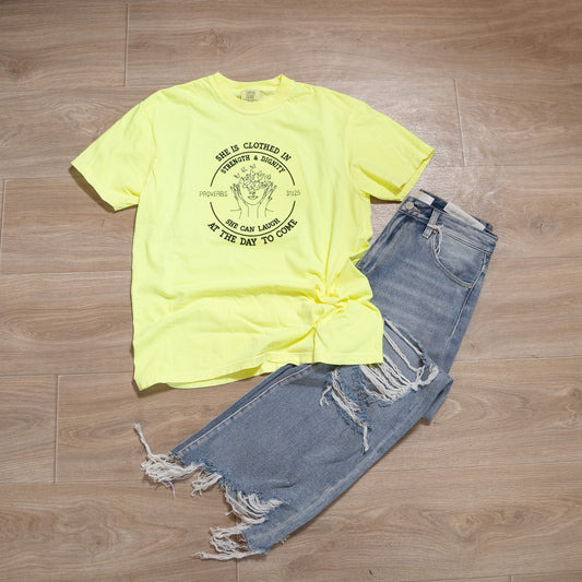 Yellow t-shirt with graphic design and blue jeans on a wooden floor