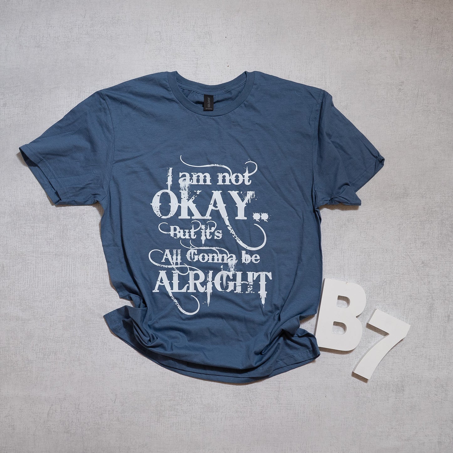 “I Am Not Okay But It’s All Gonna Be Alright” Graphic Tee – Uplifting & Relatable Everyday Comfort 🌤️