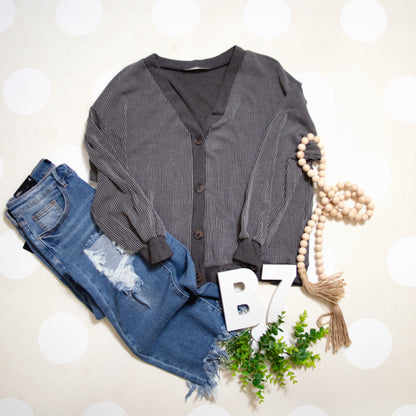 Flat Lay of Black Charcoal Cozy Confidence Button Front Top by Stylive with Distressed Jeans and Boho Decor