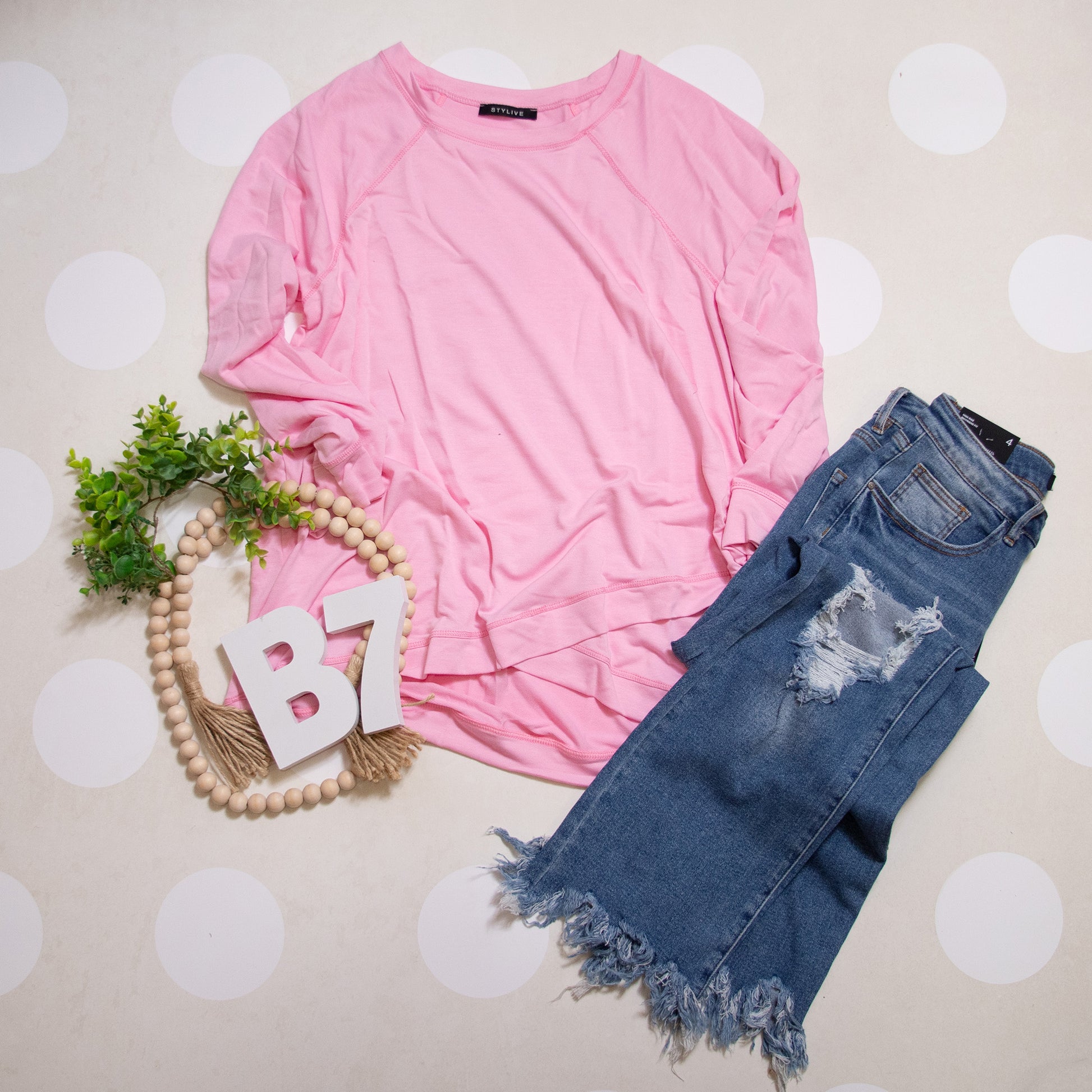 Flat Lay of Pink Plus Size Everyday Essential Long Sleeve Top by Stylive with Distressed Jeans and Boho Decor