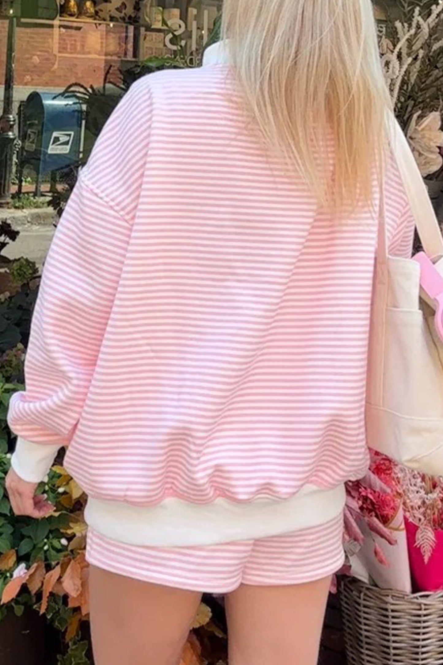 Person wearing a pink and white striped outfit with a blurred background