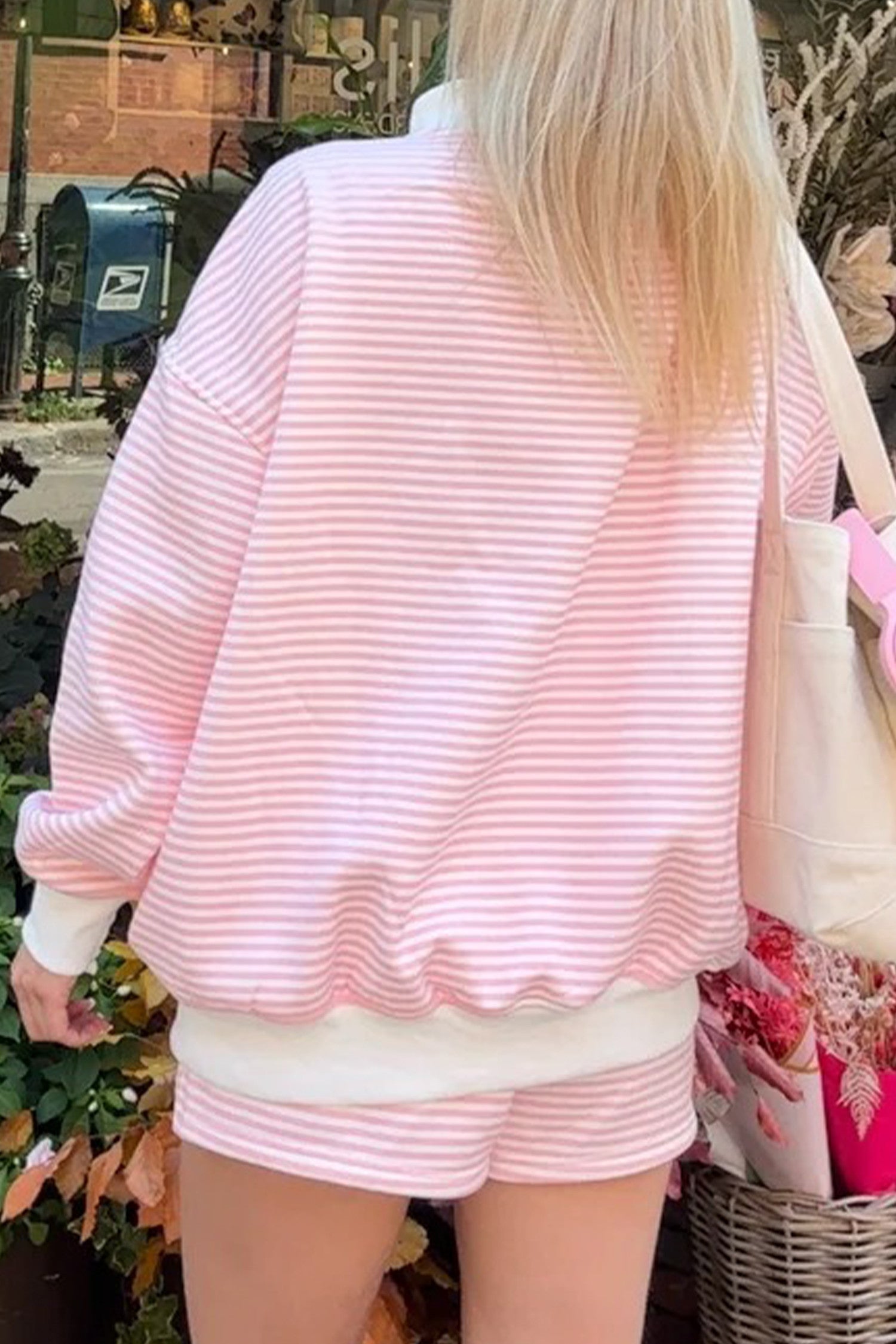 Person wearing a pink and white striped outfit with a blurred background