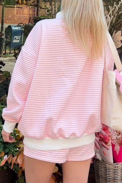 Person wearing a pink and white striped outfit with a blurred background